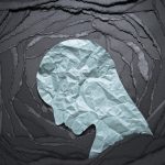 Silhouette of depressed and anxiety person head. Negative emotion image. Person head shaped paper on black torn paper background.